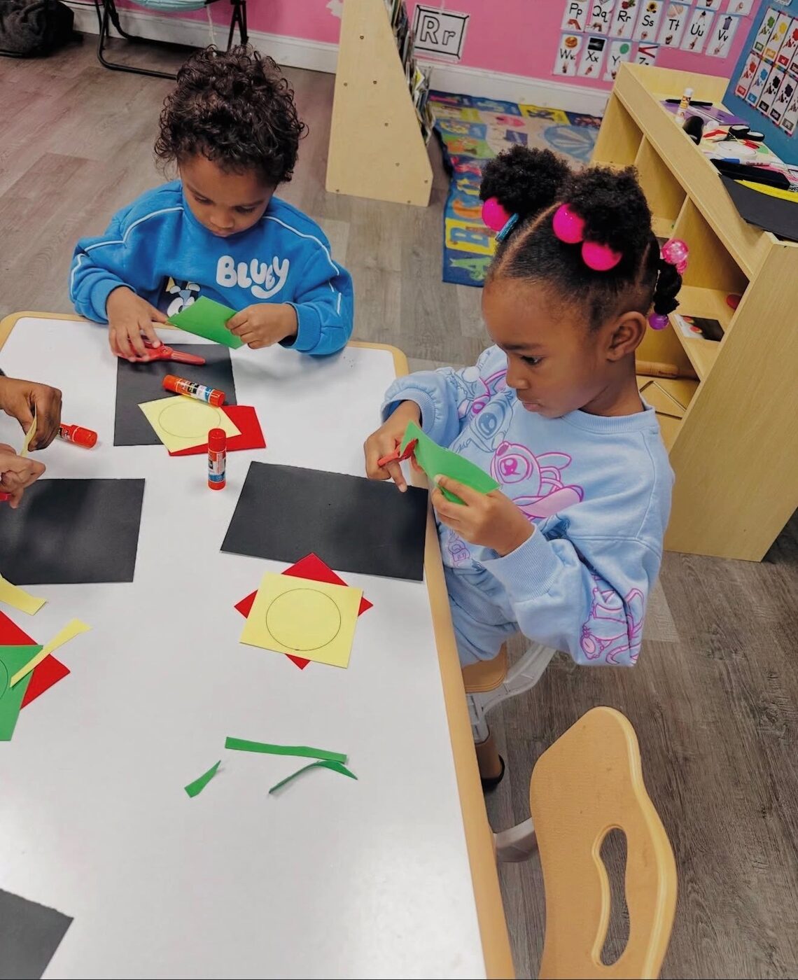 Toddlers doing a hands-on shape craft together at Happy Hearts Academy Raleigh