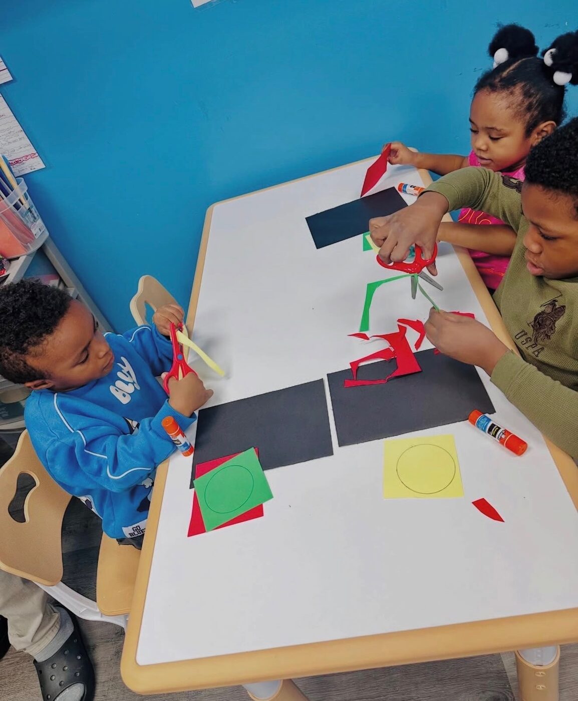 Three children collaborating on an activity at Happy Hearts Academy