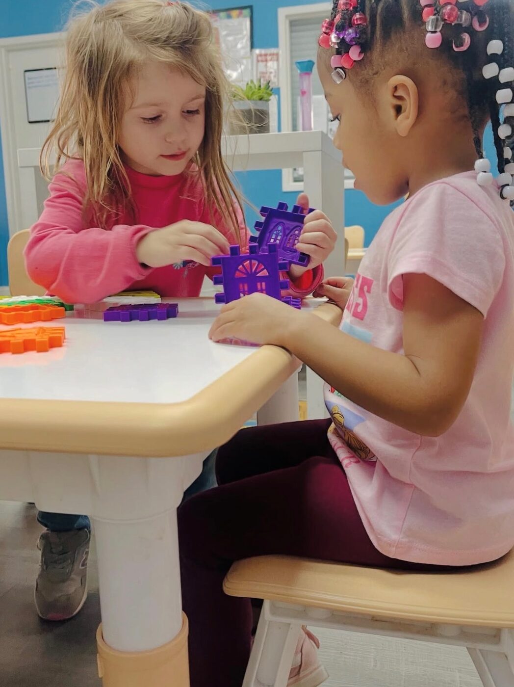 Two happy children building blocks together at Happy Hearts Academy daycare in Raleigh, NC